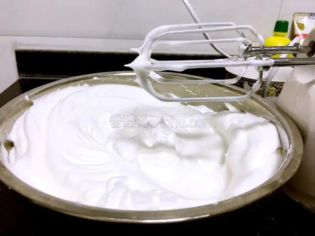 打蛋器转为中速继续打发至蛋白成硬性发泡。硬性发泡就是提起打蛋器，蛋白成尖尖的角，不弯不塌。