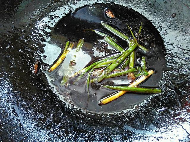 将葱段放入锅中，混合走油肉剩下的汤汁炒至葱段断生。