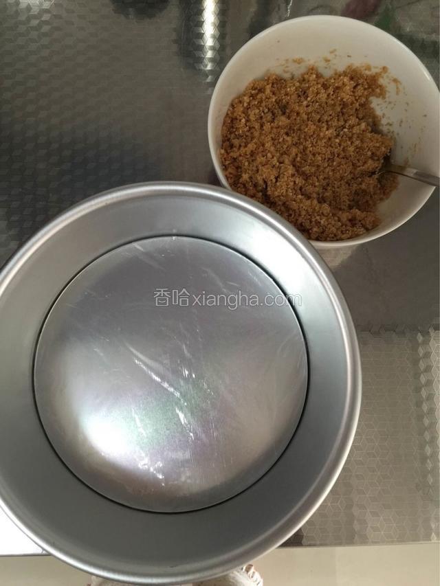 黄油隔水融化，饼干放入保鲜袋用擀面杖碾碎后倒入融化好的黄油里，搅拌均匀之后倒入模具里，压实（活底模具铺一层保鲜膜有利于脱模哦）