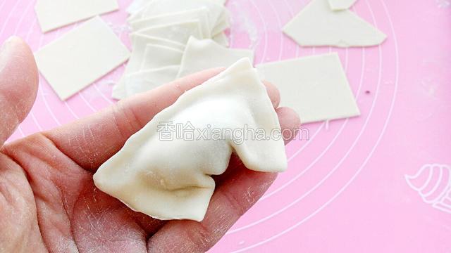 下面两个角往一起捏。