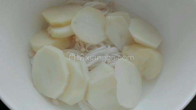 土豆与金针菇煮软后，盛入碗中底部。