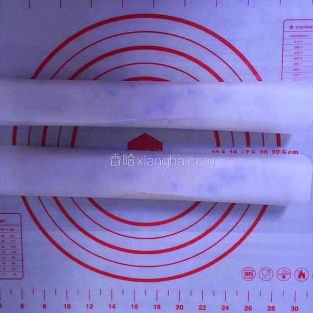 将面团分成两等份，分别用手整形成条状（新手可以借助模具），用油纸包好，放入冰箱冷冻一小时。