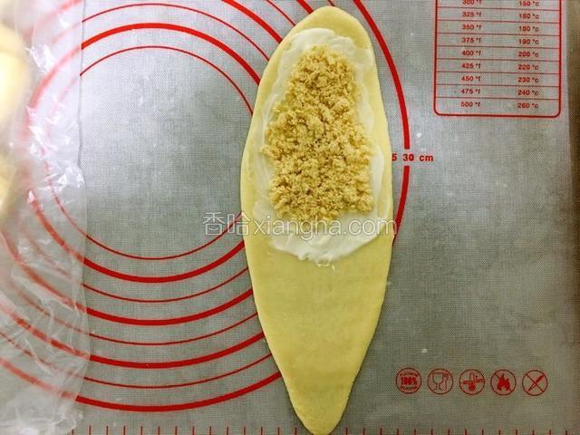 然后取一个小面团擀成椭圆形。在面片上部的三分之二处涂抹一层沙拉酱，在铺层肉松。