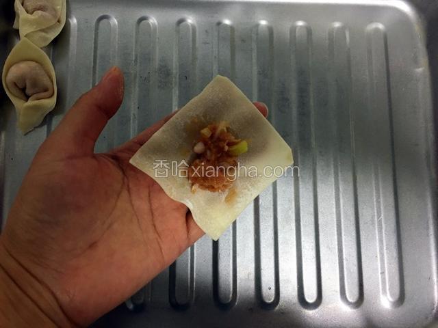 在馄饨皮中间放适量馅料。