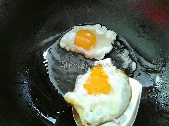 将鸭蛋轻轻挪到锅边，再打进一个鸭蛋，这样可以节省时间。轻轻用铲子翻动之前的鸭蛋，给鸭蛋翻身。煎制另一面。