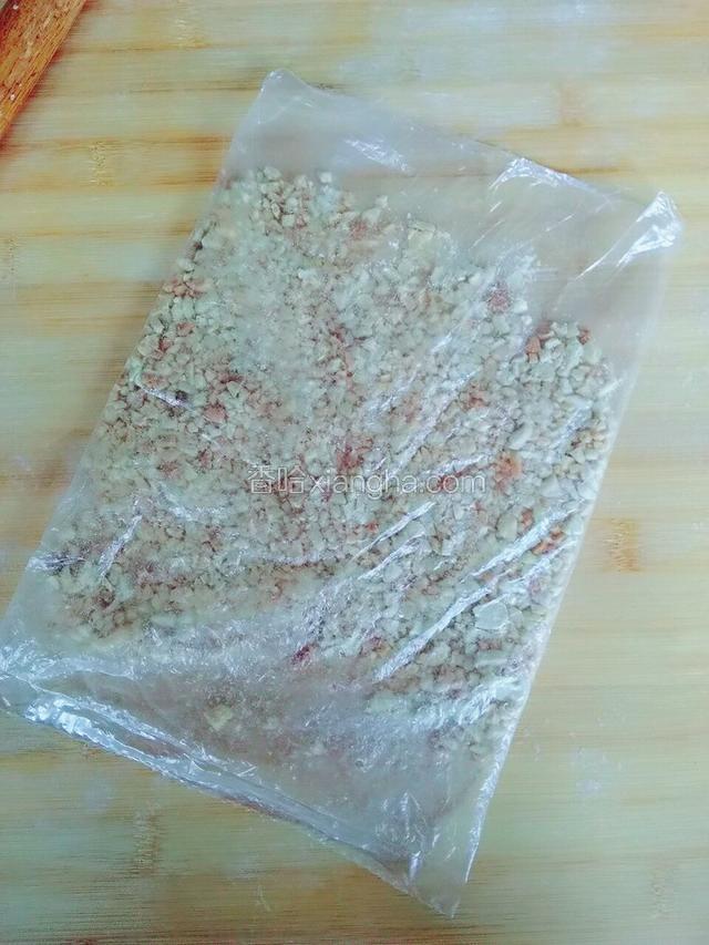 把花生装保鲜袋里，用擀面仗压碎。