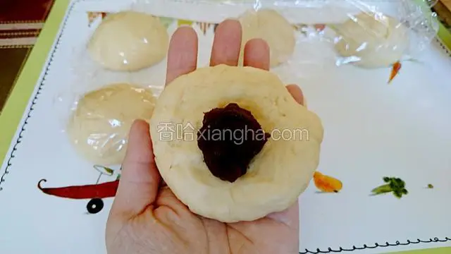 把面团按扁 中间放上豆沙馅