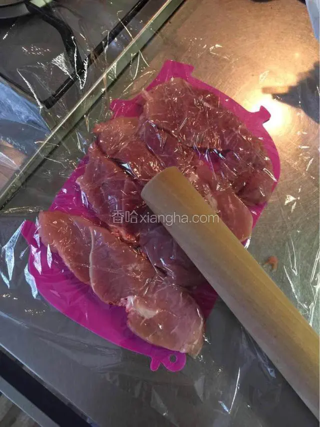 用保鲜膜盖上，用擀面棍敲打肉的表面，这样肉会变软，而且会扩大肉的面积，看起来很大，其实肉量不是那么多，可以减少肉量，完了撒些椒盐在表面上