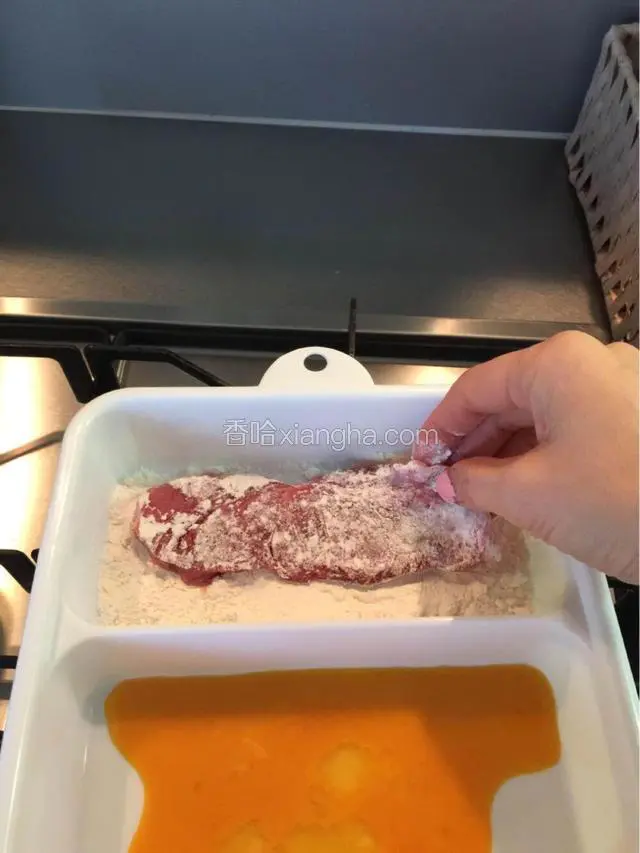 先把肉在面粉里滚过，两面都沾上薄薄的面粉