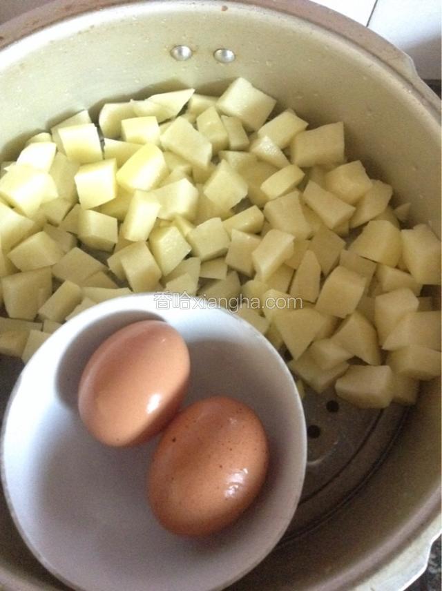 土豆切成小块和鸡蛋一起上锅蒸熟。