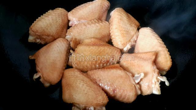 鸡翅腌至半小时后，将锅烧热,往锅里倒入食用油,油热后放入鸡翅，不要将腌鸡翅的生抽一起倒入锅里,腌制鸡翅剩下的生抽后面的步骤还会用到,将鸡翅两面煎至金黄。