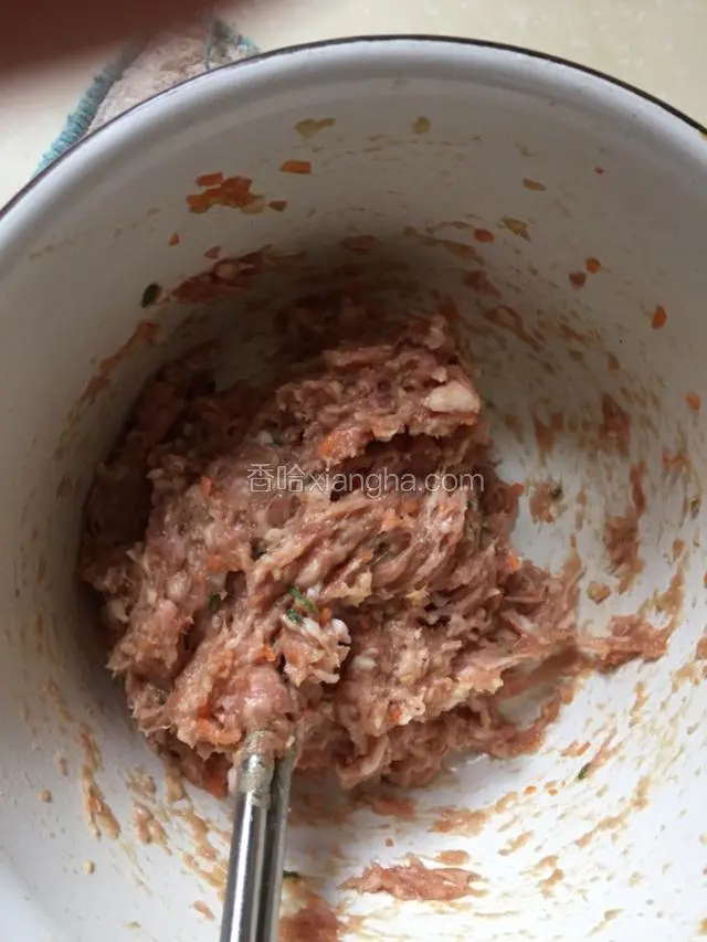 肉馅里打入蛋白放入葱姜末，各种调料拌匀往一个方向上劲搅拌。