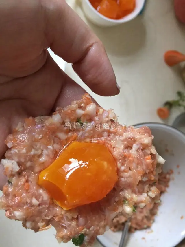取一块肉，捏成饼，放上浸泡后的蛋黄。