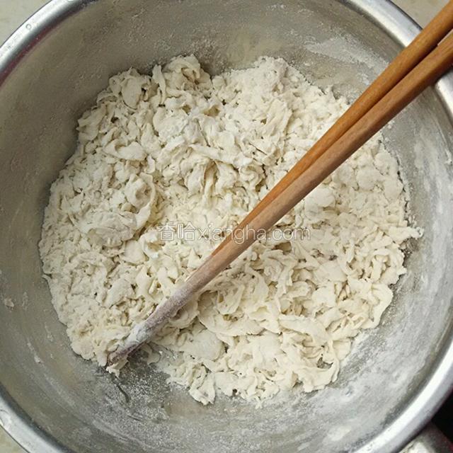将面粉倒入一个深而略大的容器，少量多次加入清水，搅拌成絮状。