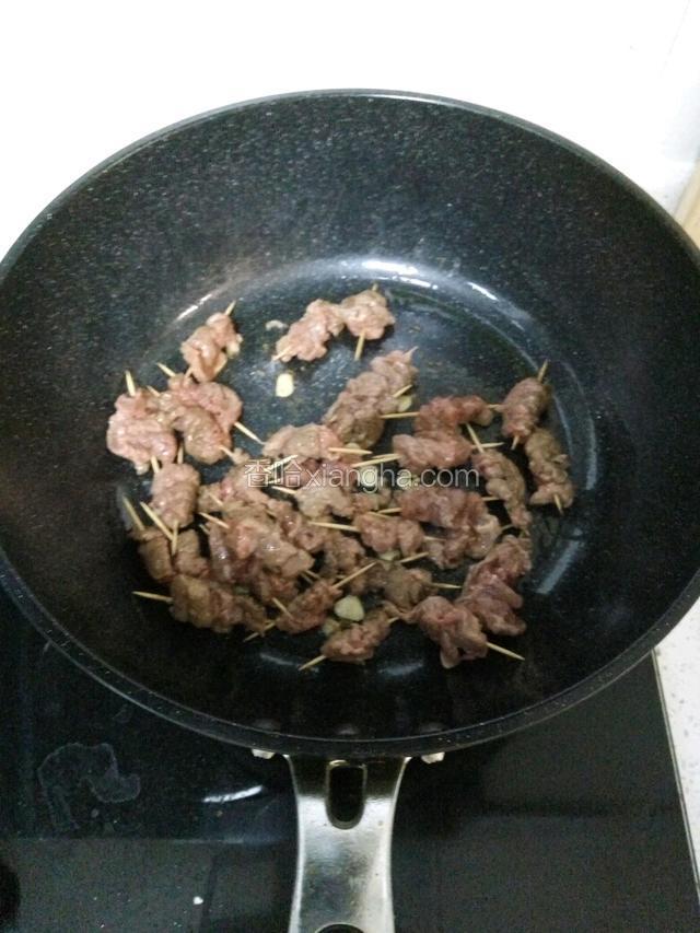 锅烧油烹香蒜片，加入牛肉大火翻炒几下加入老抽，生抽，盐，鸡精，辣椒碎继续翻炒，关火