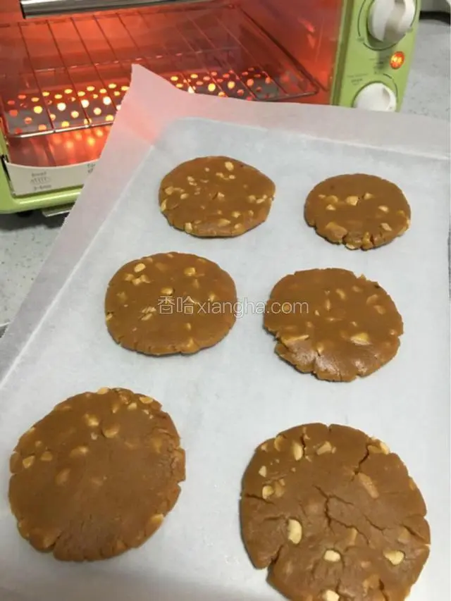 利用拳头和手指的力量压成饼状，旁边稍微开裂没有关系。同时烤箱预热140度，5分钟。（我家烤箱温度偏高，所以我设置的温度低，如果温度偏低则设置170度）