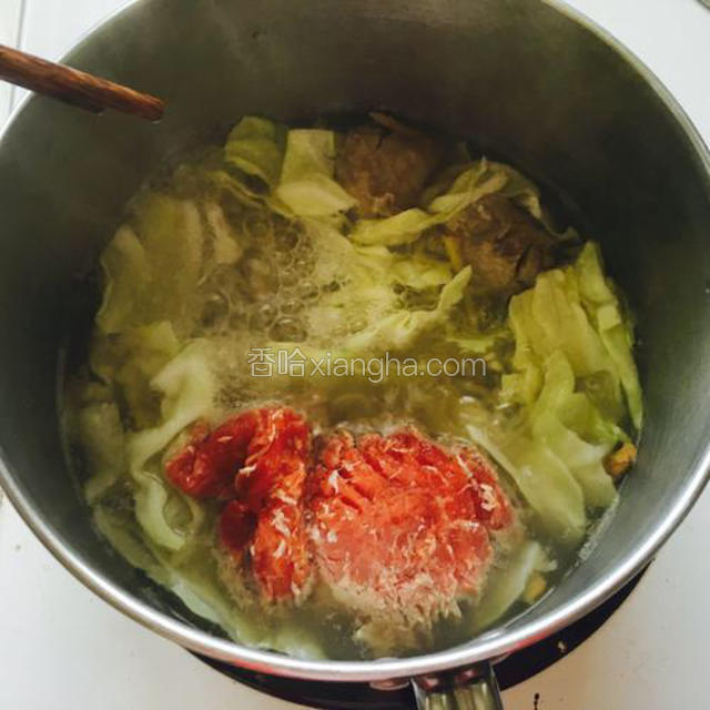 水滚后，把包菜和牛肉放入锅里煮 