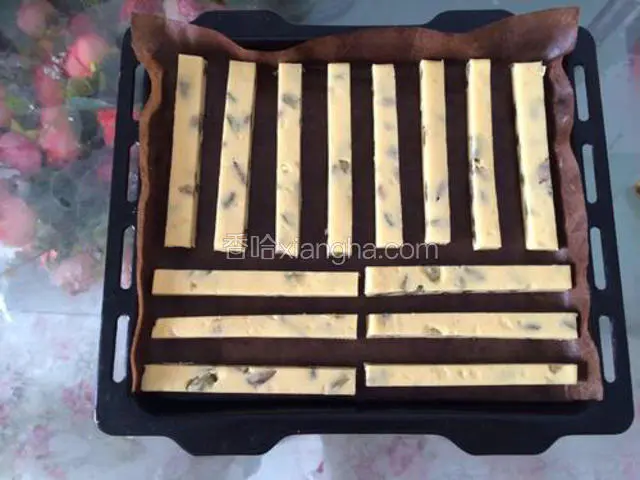 取出用菜刀切成小拇指粗细的条状，有间隔的摆放在烤盘里