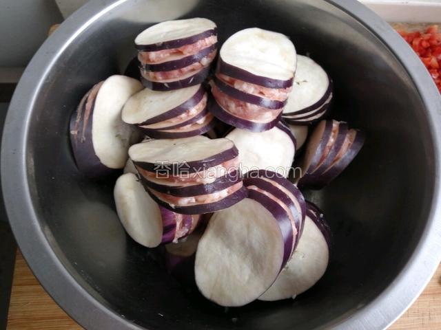 将肉馅均匀的夹在每个茄盒的夹里面（肉馅一定不能放多了，而且要放的均匀不然炸的时候容易掉出来，放肉馅的时候一定要用手捏一下使肉馅和茄子粘结更牢固一点）