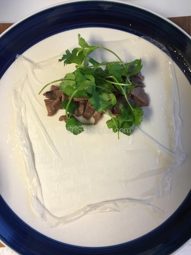 把春卷皮拉开，先加入牛舌和香菜