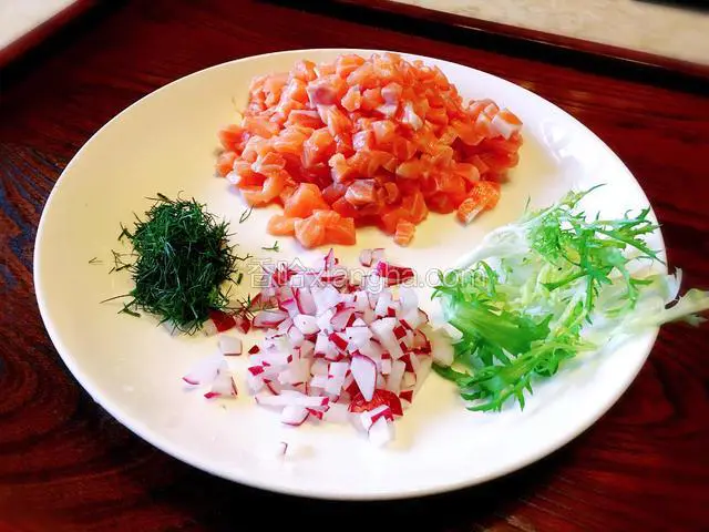 三文鱼片去皮，顺着鱼肉的纹理先切条再切丁，樱桃胡萝卜切丁，茴香剁碎（有去腥提香的作用）。