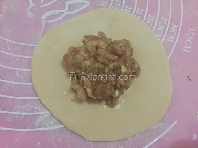 .分成小的面团，取一个小面团用擀面杖擀开成饼，放入馅料
