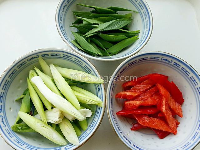 蒜苗切斜段，蒜白和蒜青叶分开；红椒切斜段