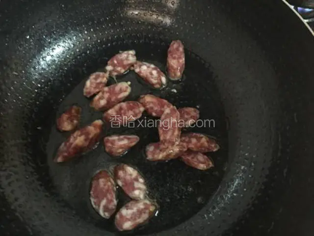 锅中放入适量的油，烧热后放入腊肠翻炒片刻
