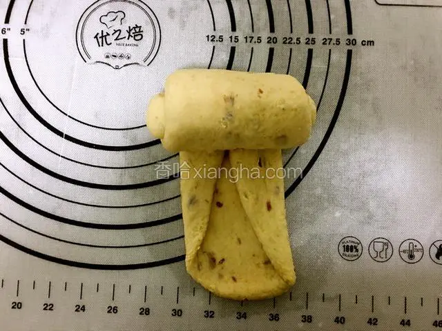 取一面团擀成长椭圆形，两个长边向内折，在由上往下卷成卷。