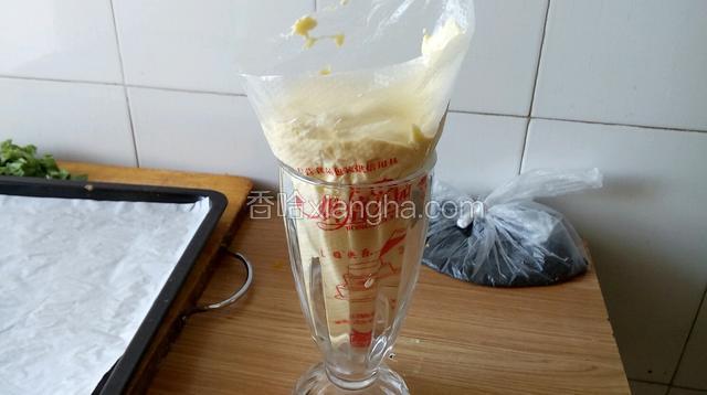 翻拌均匀后的面糊放入裱花袋中，底部剪一个小手指粗的，口子。