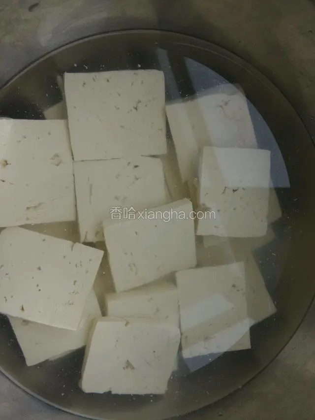 一干净盆加一勺盐，少许鸡粉放豆腐块浸泡10分钟。