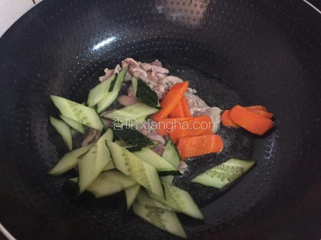 炒至肉片变色变白后放入胡萝卜、青瓜翻炒片刻