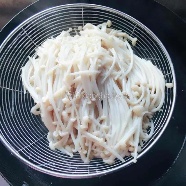 锅里金针菇焯熟之后，用漏勺捞出沥干水分