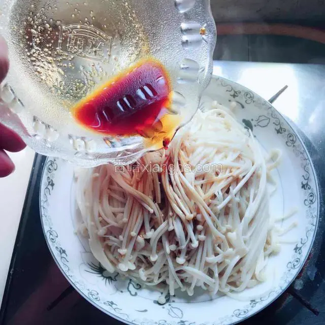 金针菇水分沥干之后用干净的盘子装起来，再把调好的酱汁浇上去