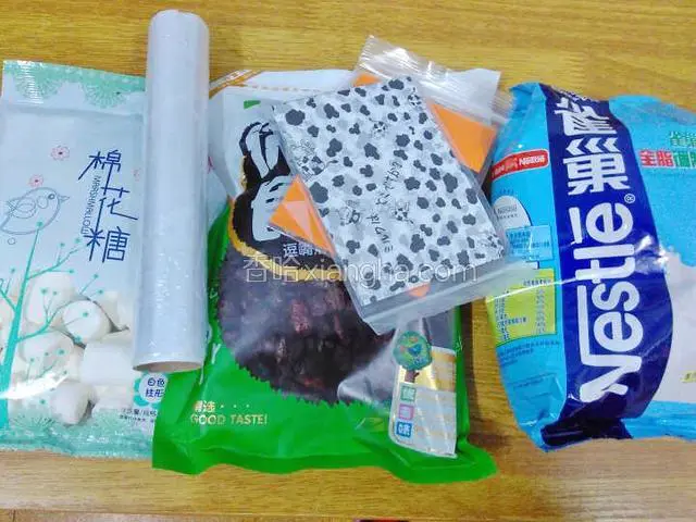 准备材料：玉米油，蔓越莓干，棉花糖，奶粉，糖纸，保鲜膜。
