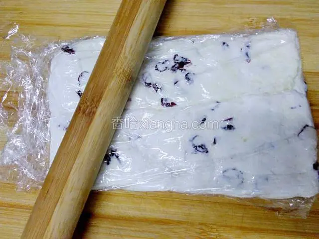 再盖上一层保鲜膜，用杆面棍把牛扎团杆平。