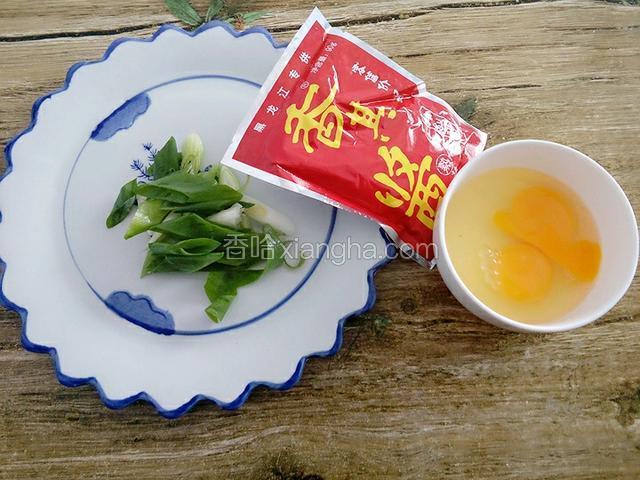 准备食材：鸡蛋磕入碗中，葱切斜刀、香其酱备用