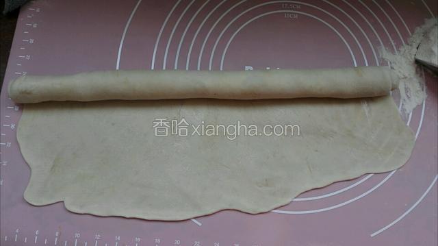 用擀面杖擀成薄薄面皮从一边卷紧