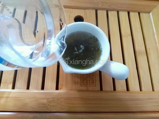 将茶叶投入杯中，倒入100克开水洗茶