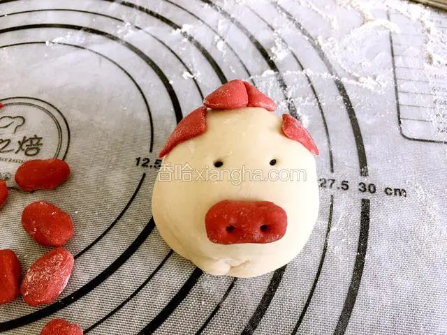 小猪的头花和领结是把面皮整成小长条，在用筷子中间夹一下。粘在小猪的耳朵中间。