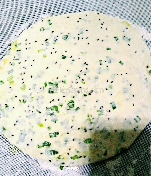 轻轻的将面团擀成圆形的薄饼。