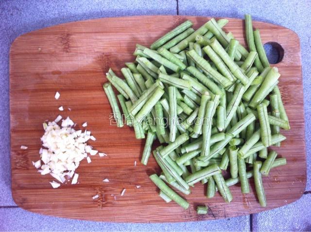 准备食材：豆角去两头和两边的丝，和蒜头一起洗净，豆角切成长度适中的段，蒜头切碎