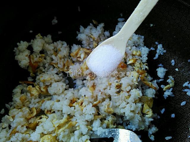 加一勺食盐，一勺白糖，一勺料酒，不断翻炒米饭和蛋，使蛋和米饭均匀混合。