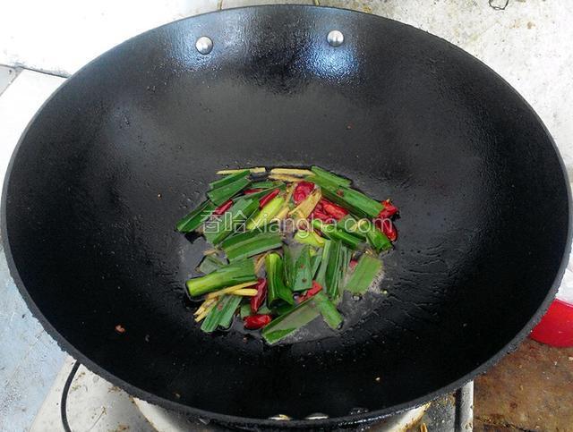 将锅里炒鸡肉剩下的油拿来炒蒜苗辣椒姜丝炒个两分钟