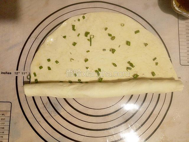 将调好的面饼由下至上卷起来，不必卷太紧。