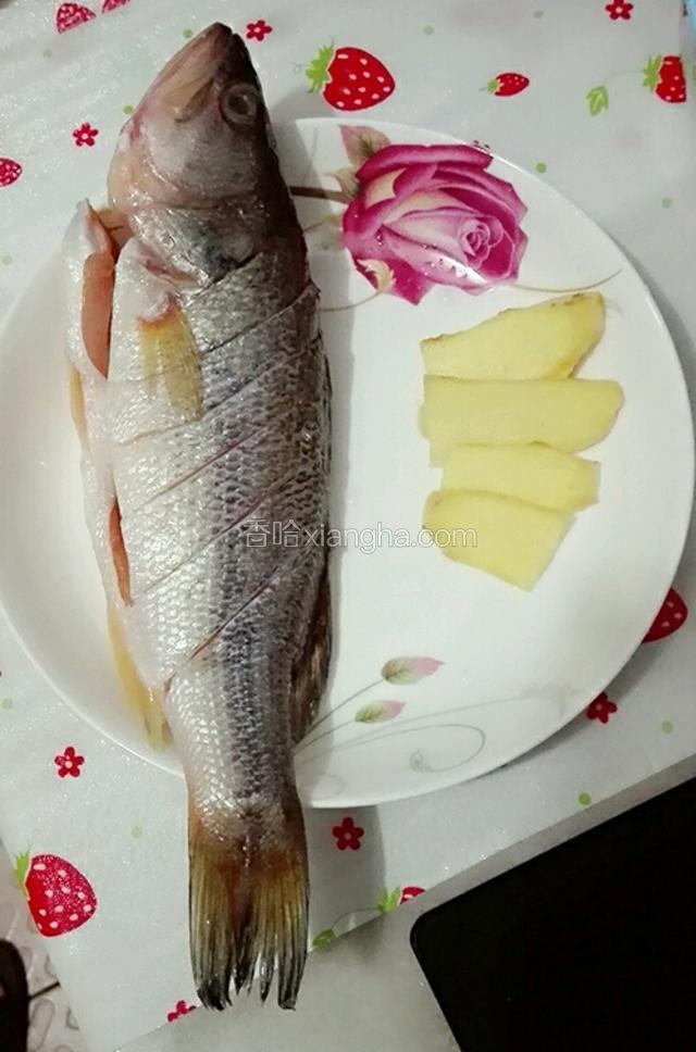 鲈鱼买回来去鱼鳞和内脏洗干净用刀在身上划上几刀，生姜去皮切片。