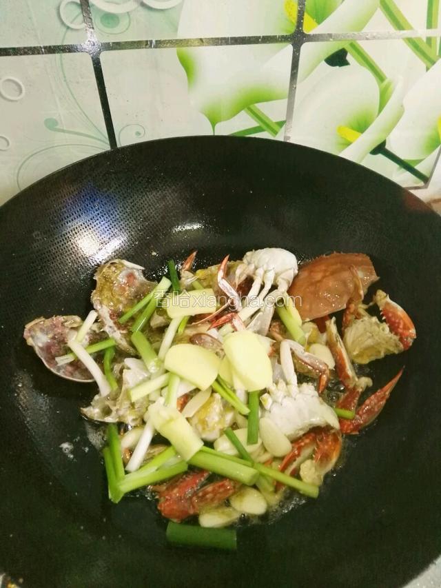 螃蟹全部变色加入葱姜蒜炒出香味