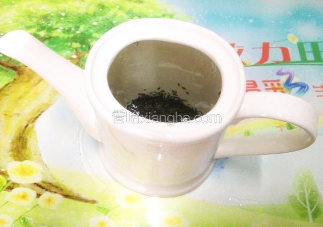 取一茶壶(大),倒入绿茶.