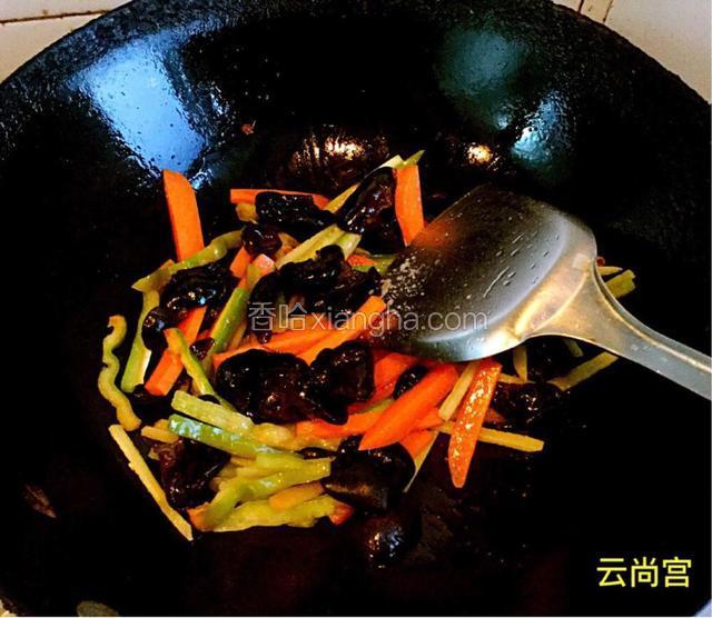 先加胡萝卜条翻炒，再依次把木耳、青椒倒入，加调合好的调味品大火翻炒。