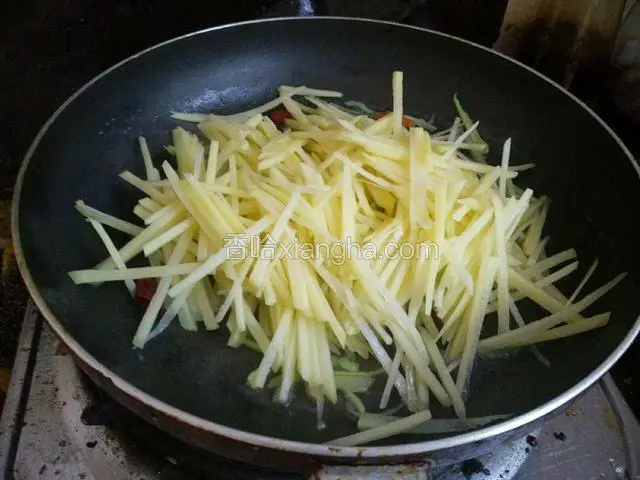 再把土豆丝捞出来控水！倒入锅中翻炒！